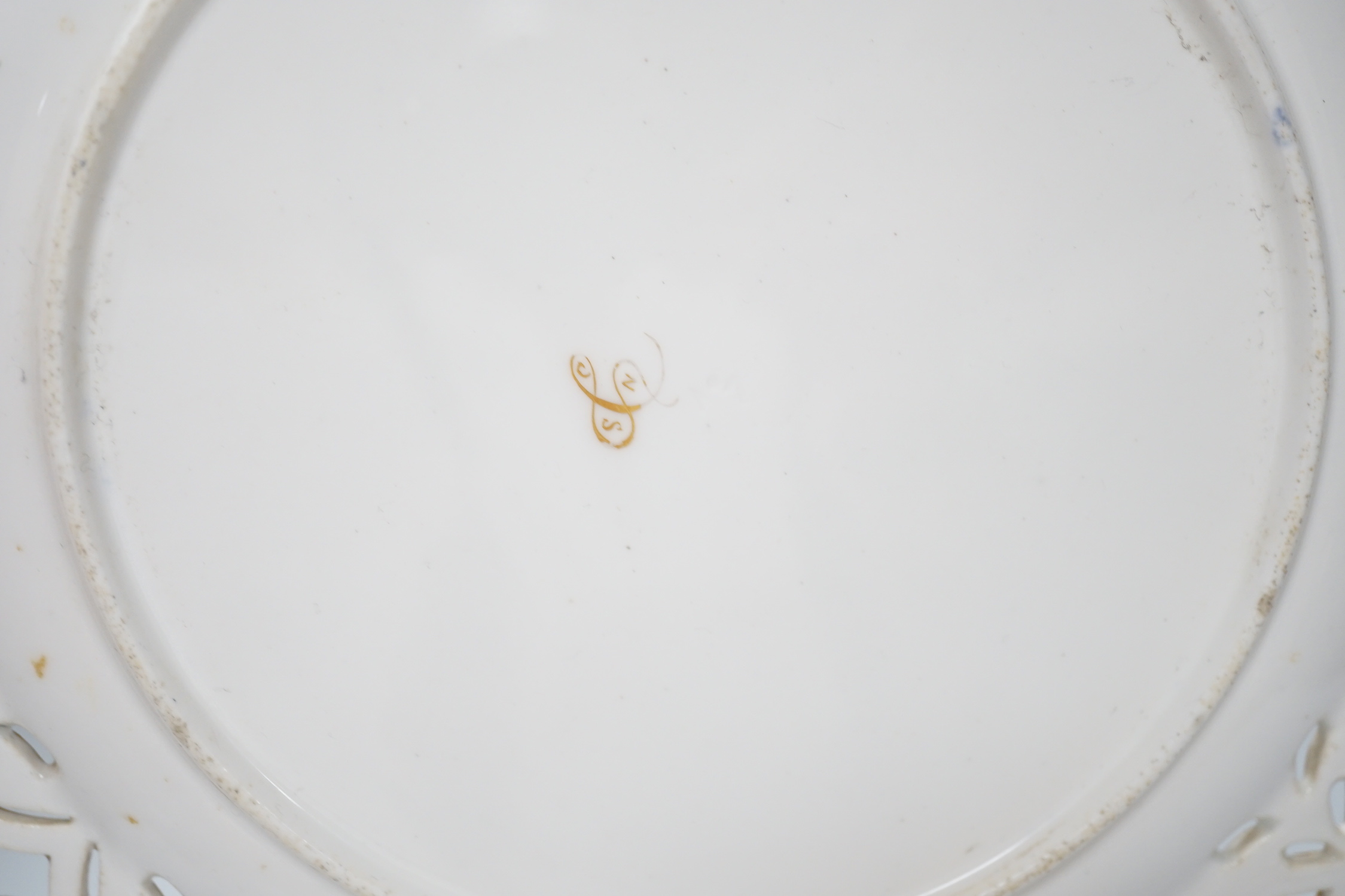 A Coalport plate with pierced border enamelled with white flowers and neo-classical raised paste gilding, the centre painted with bold flowers under jewelled inner border, ampersand mark